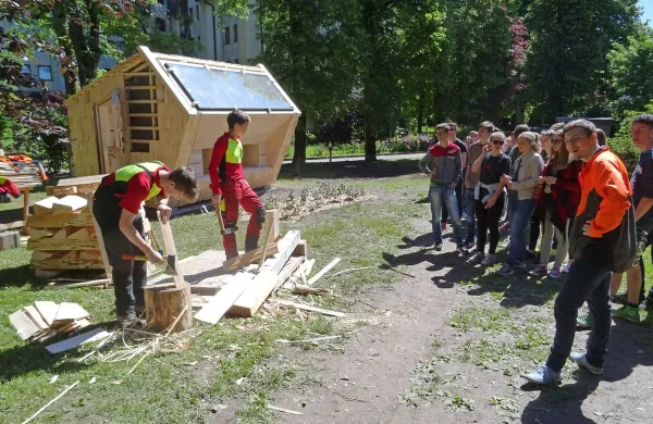  Dijaka Filip Potočnik in Gašper Jelenc sta prikazala 
izdelovanje skodel. V ozadju je objekt za apiterapijo, ki je 
prekrit in obložen s skodlami. 