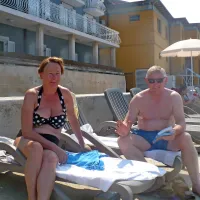 Angleški par na ležalnikih, ki zasedajo večji del plaže pred 
Hotelom Piran. 