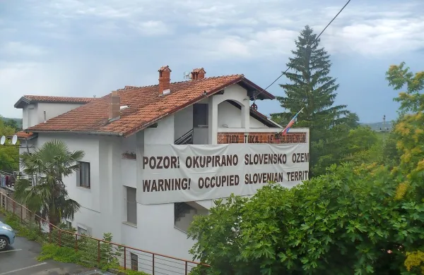 Okupirano slovensko ozemlje: tako s svoje hiše opozarja 
Joško Joras v Mlinih.  