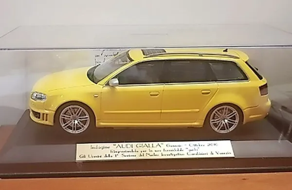 Na pisalni mizi javnega tožilca je miniatura rumenega audija; 
podarili so mu jo orožniki, s katerimi je delal na tem primeru.