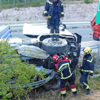 Tovornjak zapeljal v odbojno ograjo in pristal na boku