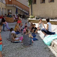 Otroci so v senci Strgulčeve hiše poslušali poučne pravljice in 
pripovedi o nekdanjem življenju na Bovškem. 