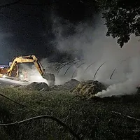 Z delovnim strojem so razkopali bale sena, da so lahko 
dokončno pogasili požar.