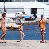 Plažno osebje (v oranžni majici) je o prepovedi obveščalo 
kopalce in skrbelo, da nihče ni “zašel” v morje. 