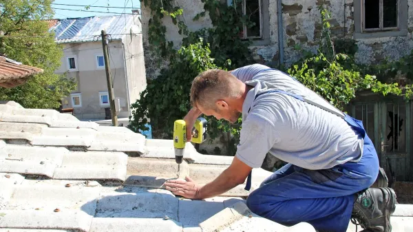 Simon Ljubič je včeraj v Zarečju popravljal preluknjano streho 
drvarnice.
