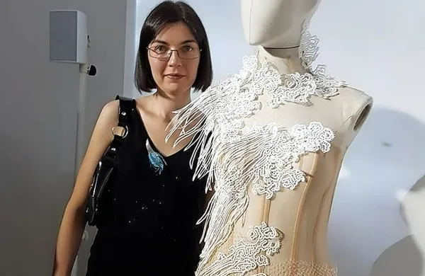 Tina Koder Grajzar ob slovesni obleki z idrijsko čipko.