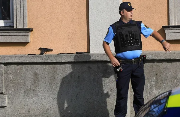 Osumljenčevo orožje na zidku za policistom