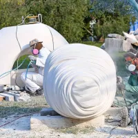 Makedonski kipar Sašo Sazdovski (v ozadju) in njegov turški 
kolega Cagdas Sari na delovišču Forma vive na Seči. 