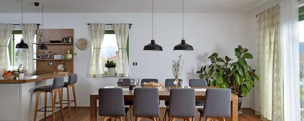 Bivalni prostor, v katerem kuhinjski otok prek velike jedilne 
mize gladko zdrsne na sedežno garnituro, se konča z 
elegantnim stopniščem, ki vodi v zgornje prostore.