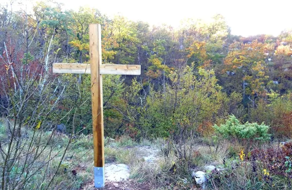 Križ na robu vhodnega brezna Kačne jame, ki označuje 
grobišče. V jami so posmrtni ostanki  domnevno 25 nemških 
vojakov. 