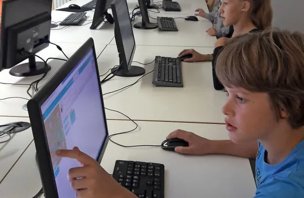 Učenci kobarišče šole med učenjem programiranja.
