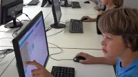 Učenci kobarišče šole med učenjem programiranja.