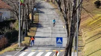 Po drevoredu,  v katerem te dni obsekavajo drevje, se proti 
dva kilometra oddaljenim Doljam po ozki in nevarni cesti 
sprehaja veliko ljudi.