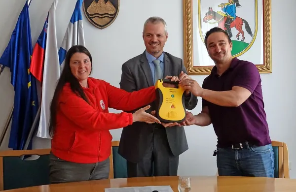 Petra Žele Šajn iz Rdečega križa je defibrilator izročila županu 
Robertu Smrdelju, on pa predsedniku vaške skupnosti Selce 
Simonu Ostanku (desno). 