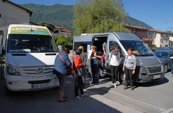 Pred kulturnim domom  v Kobaridu se je minibus iz Benečije srečal 
s kobariškim “hop-onom”.