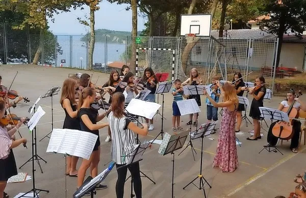Vaje mladih godalcev so v Pacugu potekale kar na prostem, na 
športnem igrišču.
