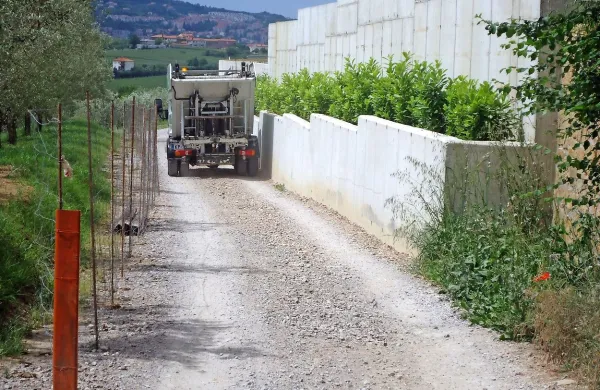 

Kovinska žica je napeta na stebričkih na eni strani, betonski zid je 
na drugi strani, vmes pa povsem zožena pot.