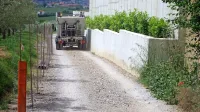 

Kovinska žica je napeta na stebričkih na eni strani, betonski zid je 
na drugi strani, vmes pa povsem zožena pot.