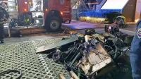 Gasilci so iz kleti pred blok prinesli uničene stvari. 