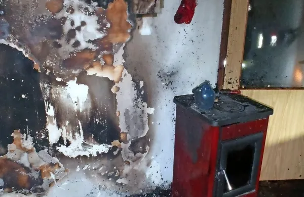 Plameni so se vneli ob kaminski peči in se razširili po prostoru. 