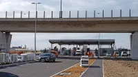 Nov vhod je pod viaduktom Bonifika. Tovornjaki  bodo do njega 
pripeljali  z avtocestnega izvoza Bertoki po bertoški vpadnici mimo 
Škocjanskega zatoka,  na krožišču pa bodo zavili desno na viadukt 
Bonifika in na naslednjem krožišču na prvem izvozu zapeljali na 
povezovalno štiripasovnico do novega vhoda.  