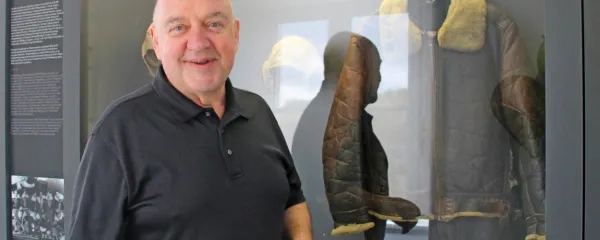  Lawrence Chalmer v  pivškem vojaškem muzeju pred vitrino z 
uniformo ameriškega letalca iz druge svetovne vojne.  