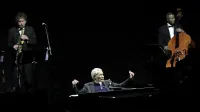 Paolo Conte, 82-letni pianist in pevec raskavega vokala, je svoji enajstčlanski glasbeni posadki poveljeval izza klavirja v osrčju odra. 