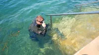 Potapljač iz državne enote za varstvo pred neeksplodiranimi 
ubojnimi sredstvi je bombo našel pri stopnicah in jo predal kolegu 
na obali.