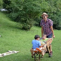 Starši in otroci so se zabavali z leseno samokolnico.