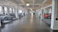 Velika večnadstropna stavba je danes preurejena v prostor, kjer 
domujejo najdražji avtomobili. Med njimi je veliko uveljavljenih 
modelov, ki pa imajo večinoma  tudi svojo ceno.