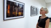 Eva Tisnikar pred eno svojih bolj barvitih fotografij, na kateri   je  poleg črne barve videti  tudi 
oranžno-rumene in modro-sive odtenke.