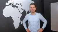 Jernej Čopi, direktor poslovnega razvoja podjetja, ob zemljevidu 
sveta, na katerem število rdečih pik, ki označujejo mesta z 
Ensolovimi kartodromi, vztrajno raste.