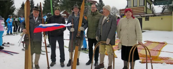 Predsednik organizatorjev Miha Butara (z zastavo) in župan 
Gašper Uršič (med smučarji po starem) zagotavljata, da spomin na 
pogumno partizansko smučarsko tekmo ne bo zamrl. 