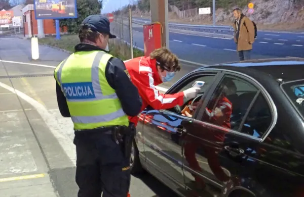 Fernetiči: prostovoljci Rdečega križa s termometrom  preverjajo 
temperaturo voznika.