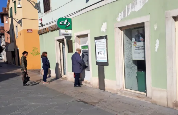 Pred poslovalnico Delavske hranilnice v Kopru so  stranke potrpežljivo čakale v vrsti pred vrati.