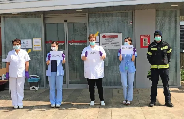  “Skupaj bomo zmogli,” sporočajo iz dežurnih    ambulant v koprskem Zdravstvenem domu s prošnjo, naj ljudje ostajajo doma. 
Na fotografiji del ekipe, ki je nenehno v pogonu,     okrepljena z 
gasilcem, ki  pomaga vzdrževati red in varnost.  