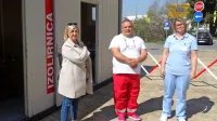 Nives Pinter (z desne), Iztok Pavalec in Vanja Kosmina Novak pred 
kontejnerjem za odvzem brisov pri koprskem  zdravstvenem 
domu.
