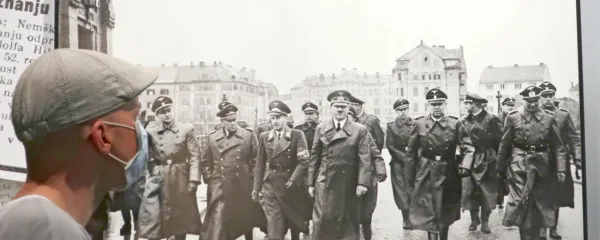 V sredini  zlovešče fotografije koraka   Adolf Hitler ob ogledu porušenega dravskega mostu v Mariboru 26. aprila 1941. 