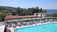 Od Hotela Delfin je poslej tudi zemljišče nasproti zunanjega bazena, kjer sta Hangar bar  in nekdanji veslaški hangar pa tudi sanitarije 
marine (desno).