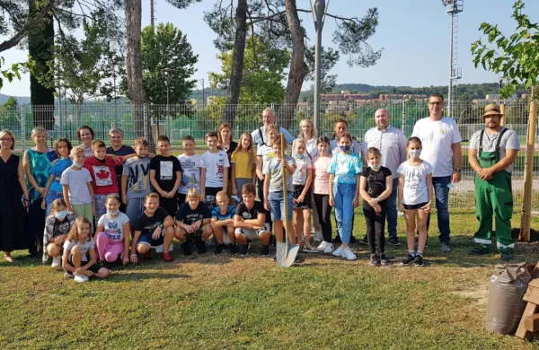 Koprski osnovnošolci so skupaj z županom Alešem Bržanom in delavci Marjetice Koper posadili nekaj dreves in tako ozelenili dvorišče OŠ Koper. (Foto: arhiv MOK)