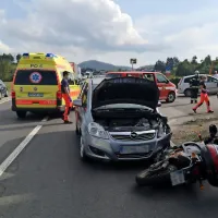Voznika  avtomobila in motorja  sta  hotela ustavljen kombi hkrati 
obvoziti, voznik avta je pri tem trčil v motorista.