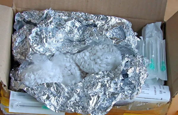 V prostoru za  rezervno  kolo so pravosodni policisti med drugim 
odkrili tudi 12.000 tablet, ki vsebujejo prepovedane snovi.  