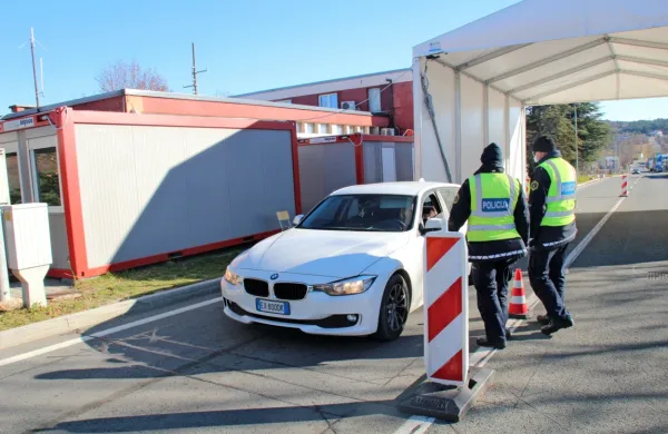Nekaj metrov od za to namenjenih zabojnikov morajo policisti v 
mrazu opravljati kontrolo na prostem.