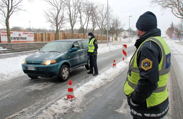 Na zasneženi cesti pod šotorom sta včeraj policista pri dveh 
stopinjah pod ničlo in močni burji kontrolirala promet na Krvavem 
potoku. 