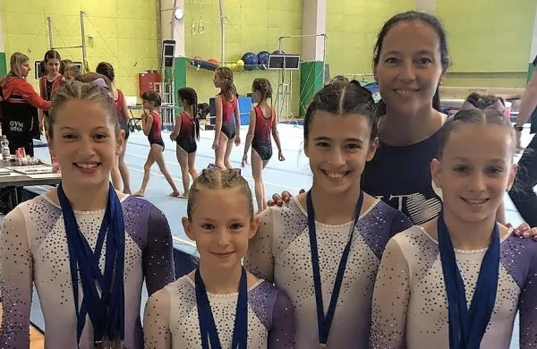 Gimnastičarke iz ŠK Salto iz Kopra z medaljami in s trenerko Vesno 
Stavrev