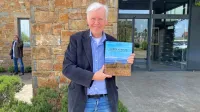 Paul Balke s svojo knjigo pred Vinakoprovo Hišo refoška.