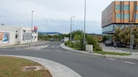 Novo krožišče bo zgrajeno na  kamionski cesti (v ozadju za 
parkiranima avtomobiloma med med  Petrolovo črpalko in hotelom Safir. Nanj bo speljan tovorni promet s  Terminala (za levim 
avtomobilom)   in iz logističnega centra (kupi zemlje za Safirjem). 