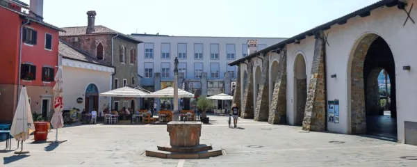 Na Carpacciovem trgu je vodnjak v obliki kapitela in Justinin steber, ki so ga postavili 
v znak zmage pri Lepantu.