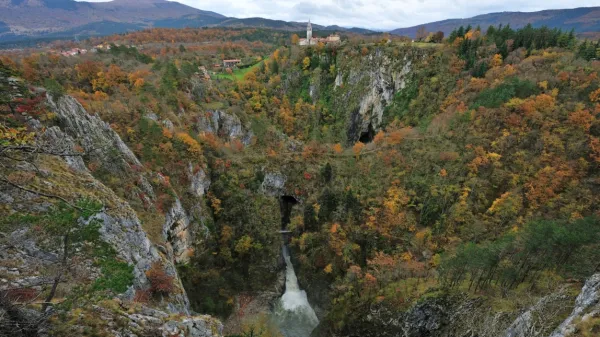 Velika dolina v jesenskih barvah s Škocjanom v ozadju.