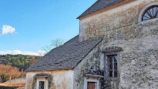 Kamnita streha zakristije ob cerkvi sv. Andeja v Merčah zamaka na 
spoju s cerkvijo, pa tudi v sredini, kjer so se skrle udrle.